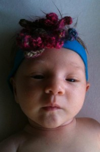 Photo of Baby DD with hand-knit flower headband on